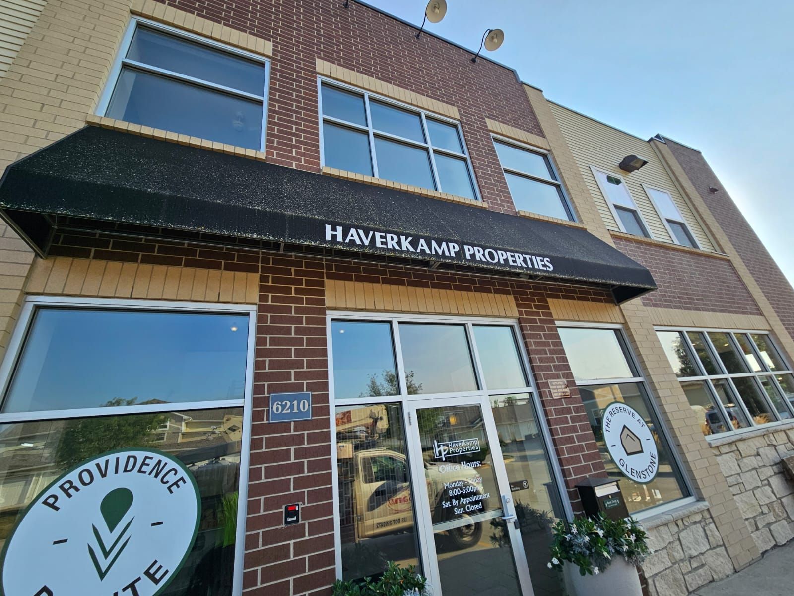A large brick building with a black awning over the entrance.