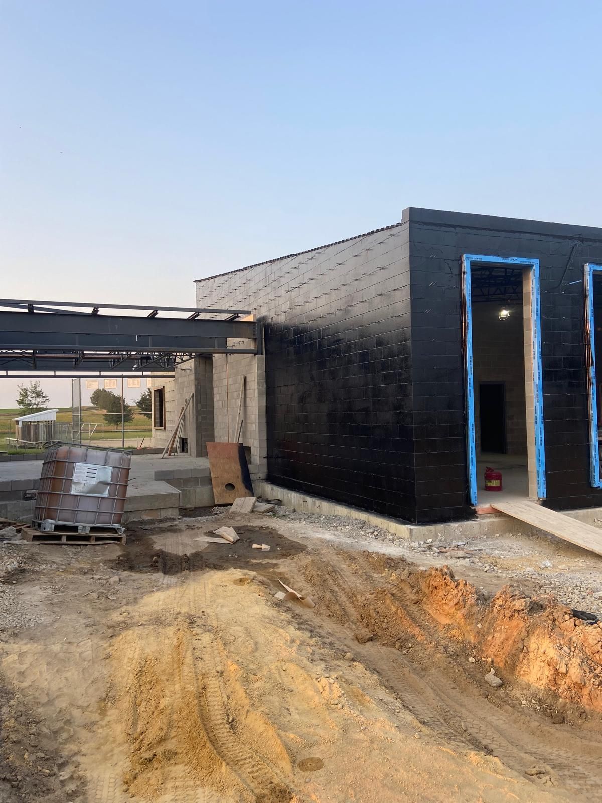 A building is being built in the middle of a dirt field.