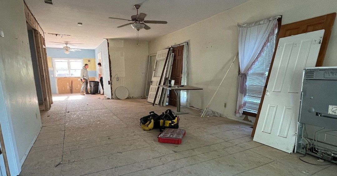 A living room with a lot of doors and a ceiling fan.