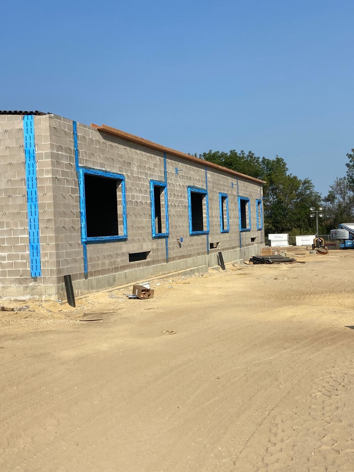 A brick building with blue trim is under construction