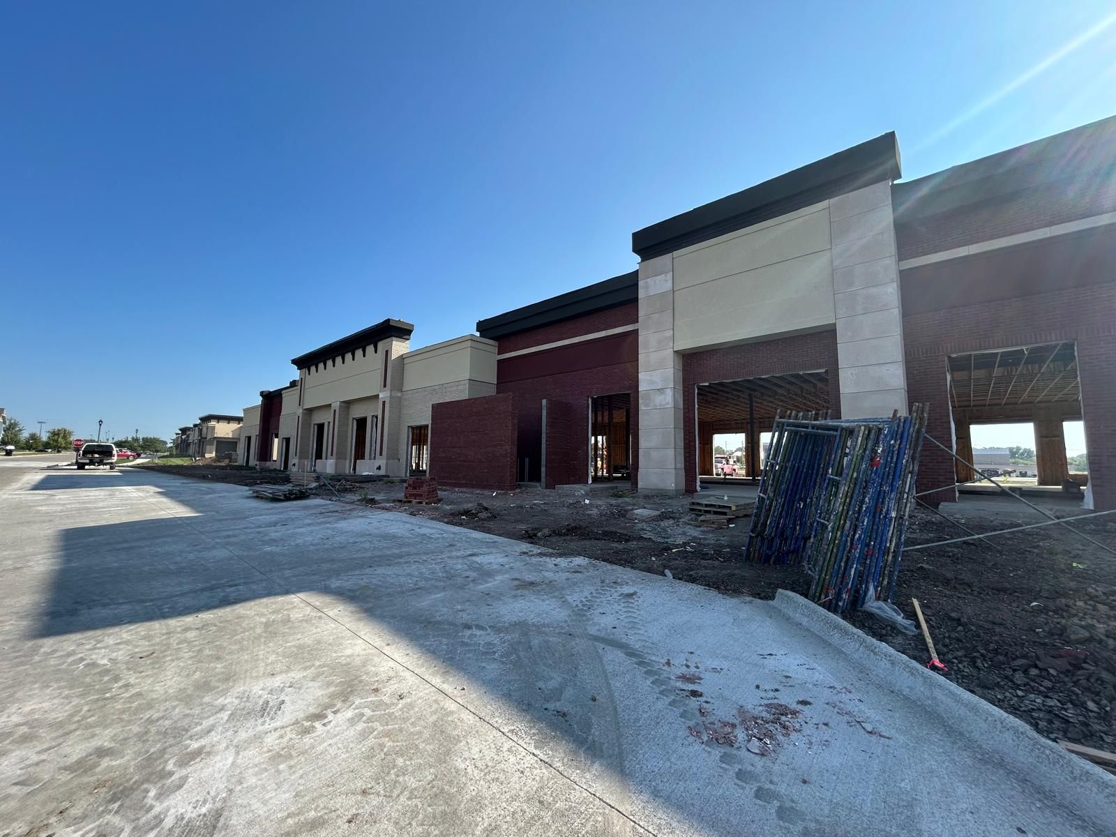 A row of brick buildings under construction with a blue sky in the background.