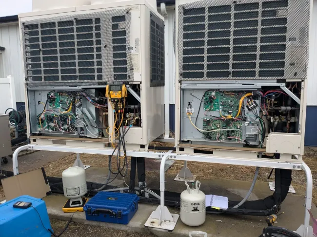 Person wearing gloves cleaning an air conditioner.