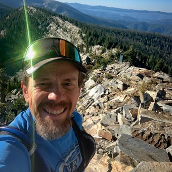 A man taking a selfie on top of a mountain