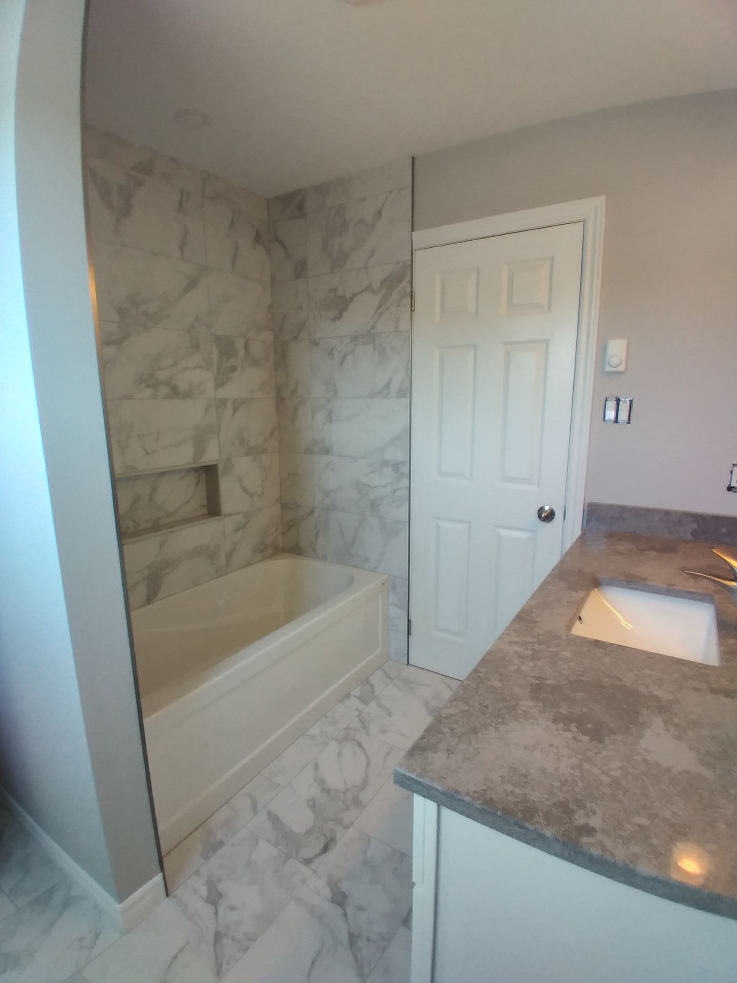 Tiled tub surround White tub with tiled shower and niche