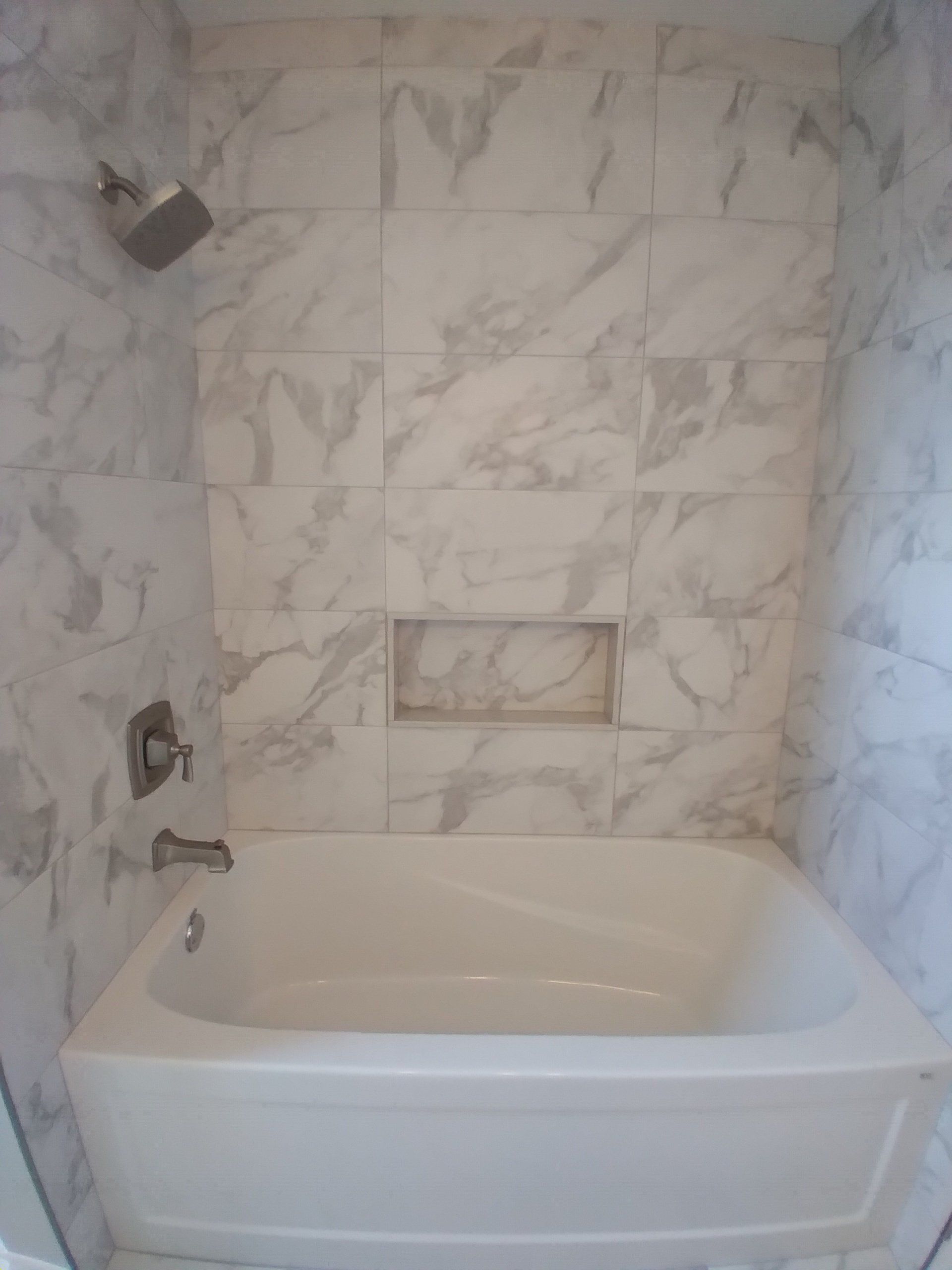 Tiled tub surround White tub with tiled shower and niche