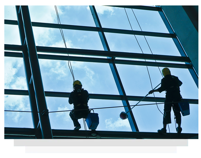 Two men are cleaning the windows of a building.