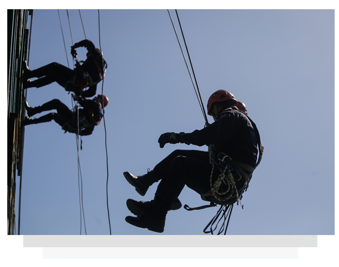 Three men hanging from a rope.