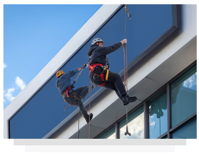 Two men climbing up the side of a building.