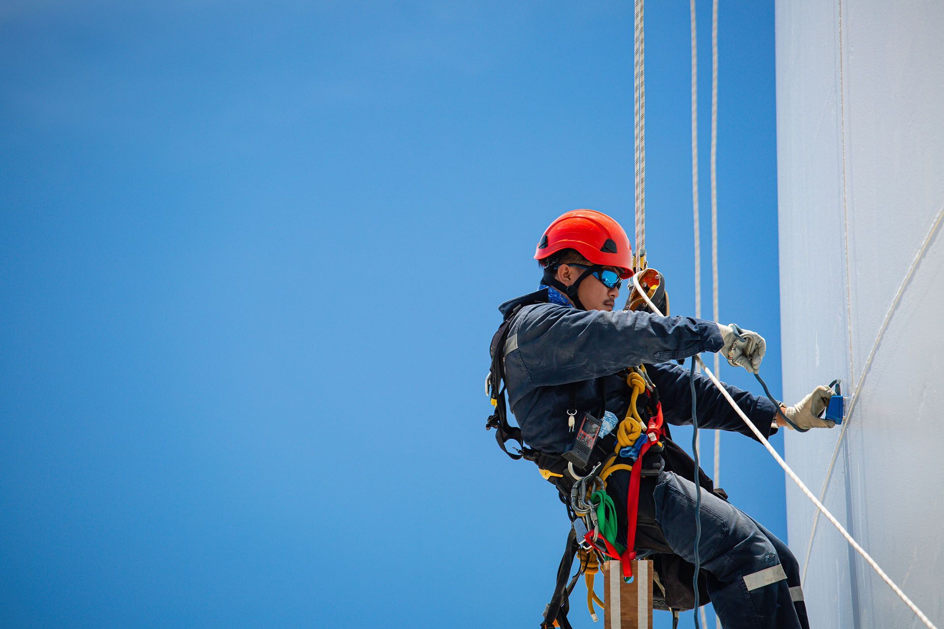 A man is climbing a building with a rope.
