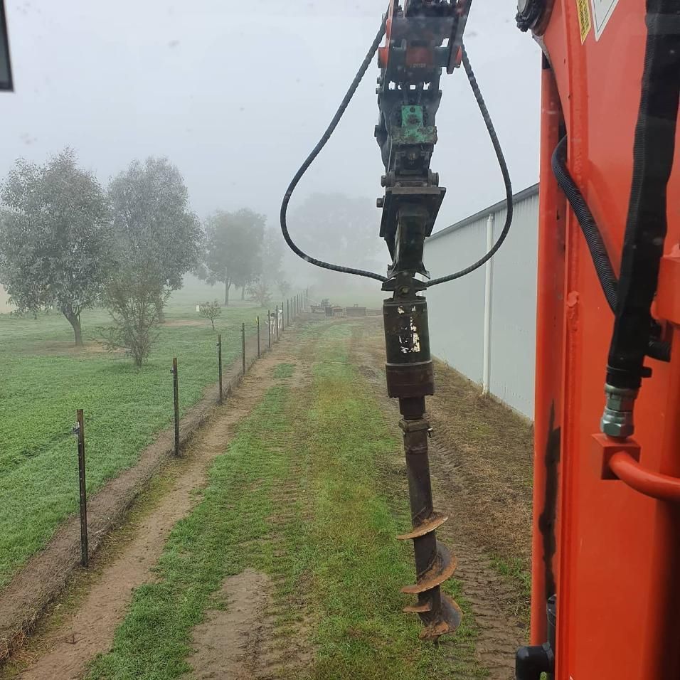 An Orange Tractor Is Driving Down A Dirt Road — Grants Excavations In Osbornes Flat, VIC