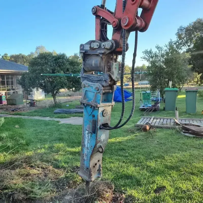A Blue And Red Machine Is Sitting In The Grass — Grants Excavations In Osbornes Flat, VIC