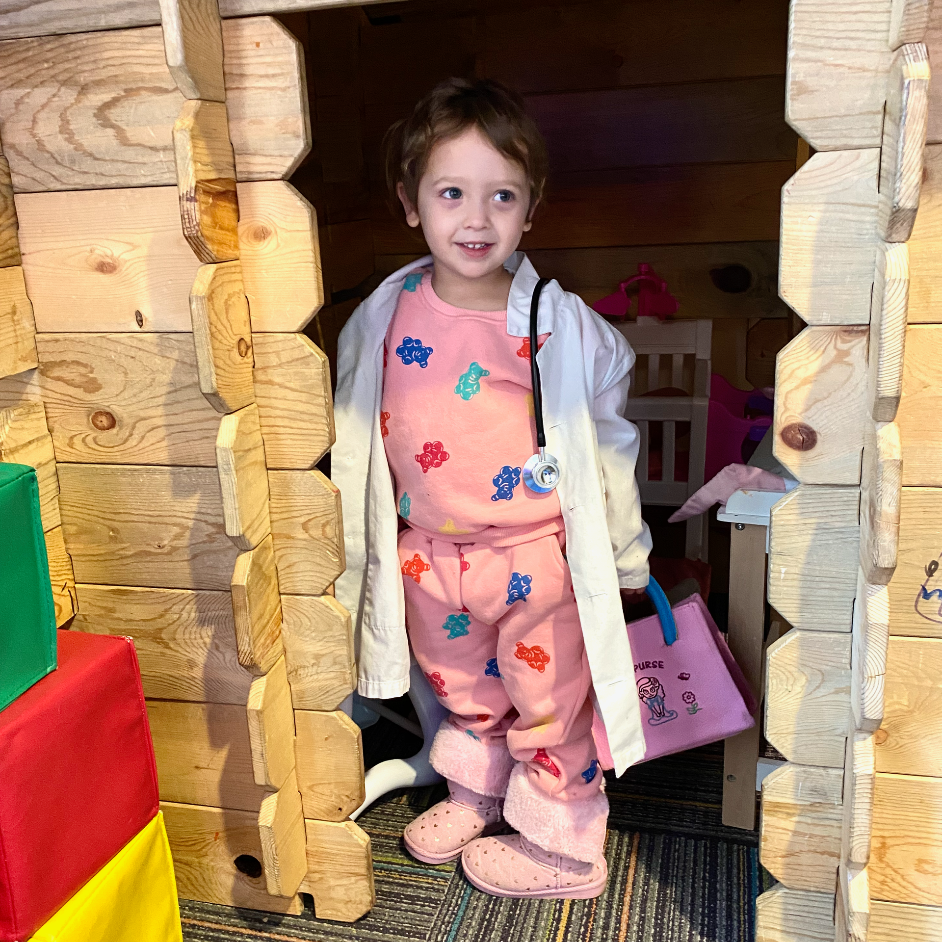 Toddler playing in toy house at a pediatricians office