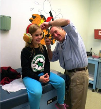 Doctor checking girl's ear A doctor checking a young girl's ear.