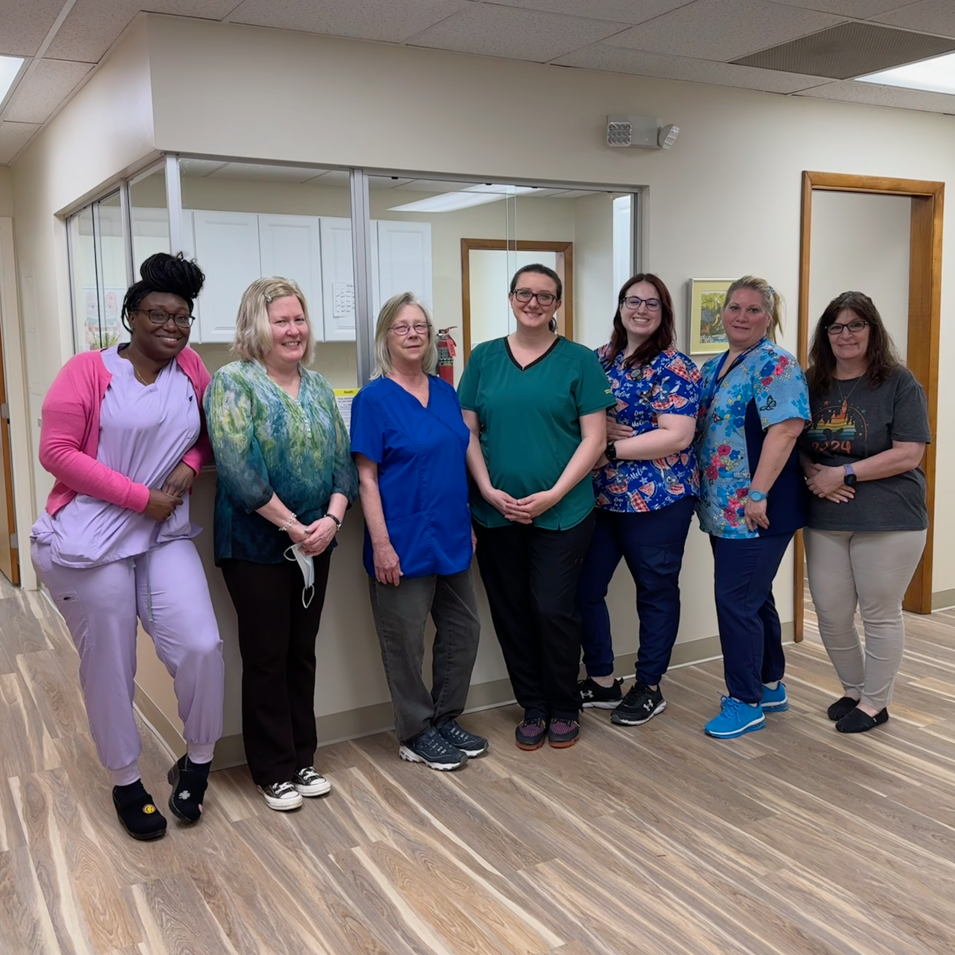 A group of women are posing for a picture in a room.