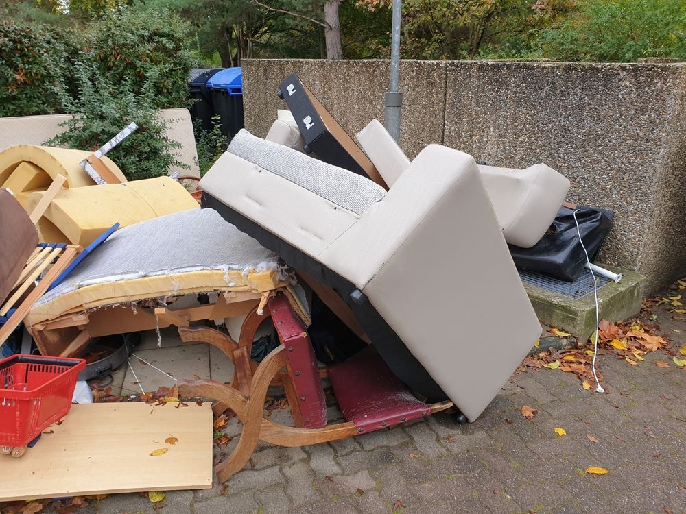 A pile of furniture is sitting on the ground in front of a wall.