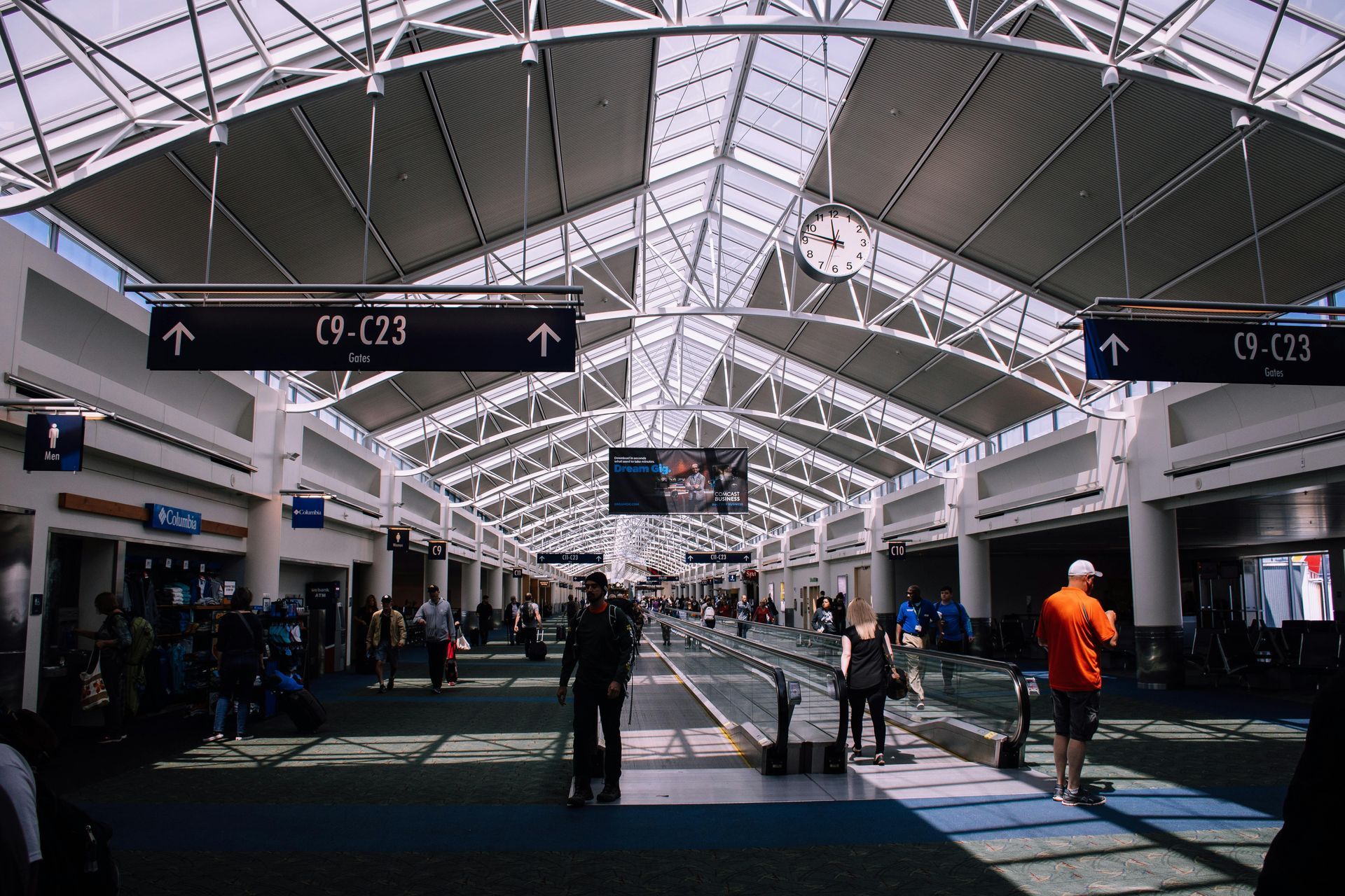 A group of people are walking through an airport terminal.