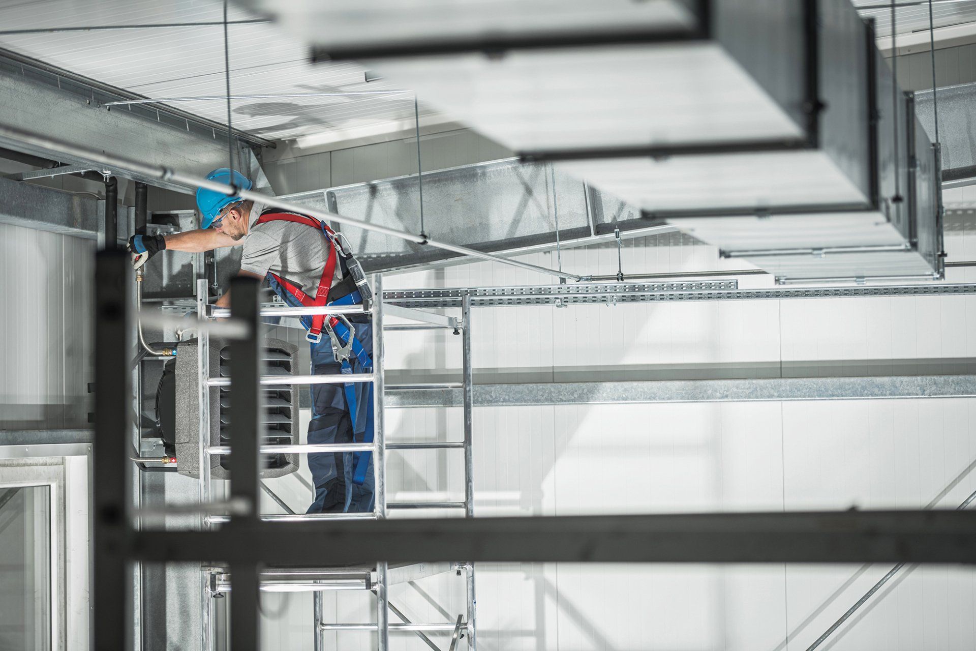 A man is working on installing a warm air heater in a building.