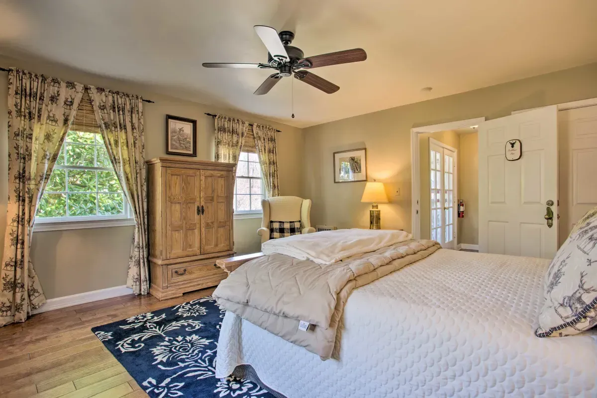 a bedroom with two beds , a ceiling fan , a rug and a window .
