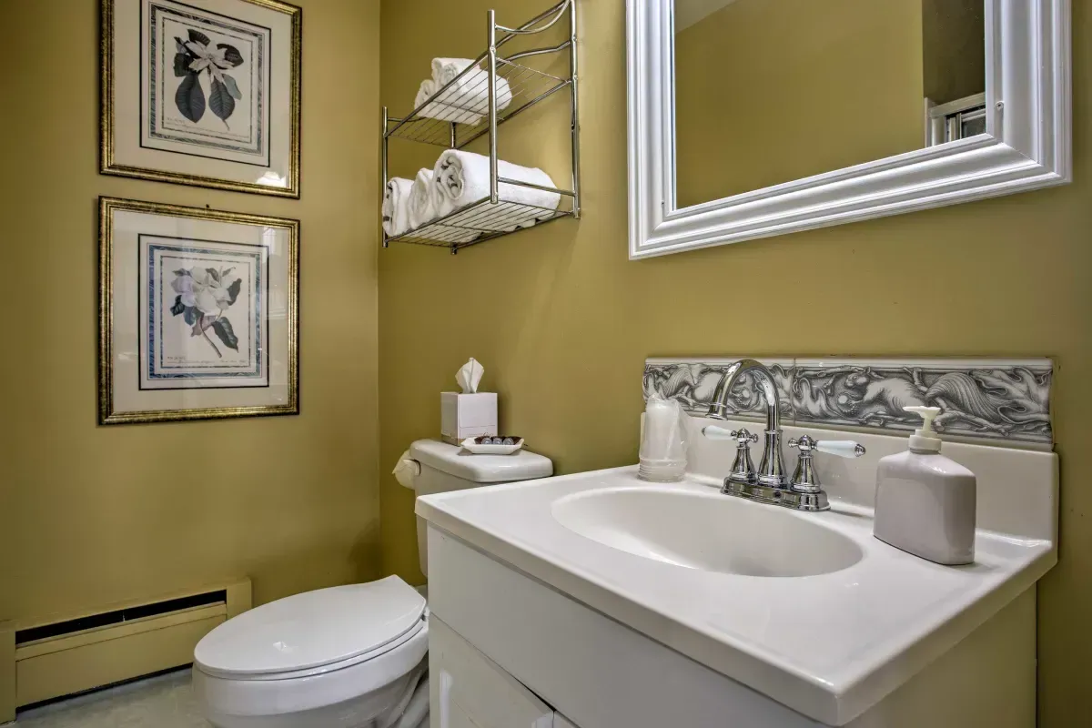 a bathroom with a sink , toilet and mirror .