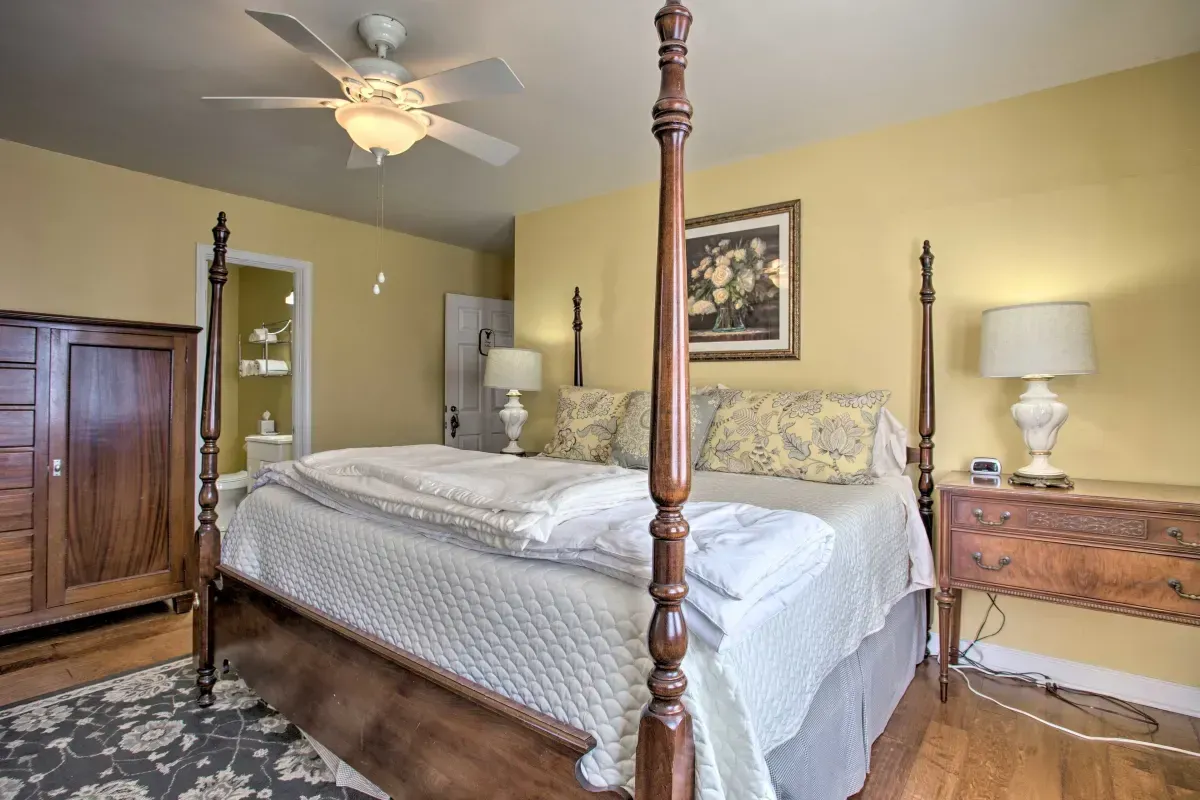 a bedroom with a four poster bed and a ceiling fan .