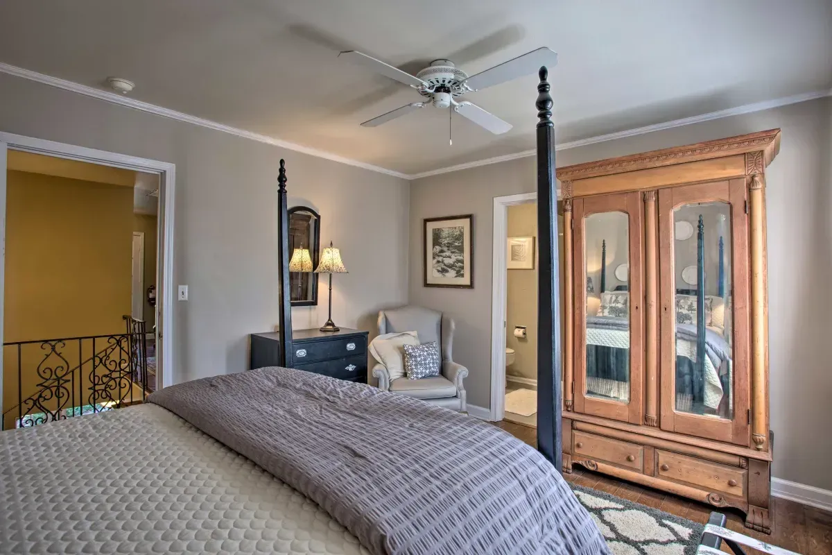 a bedroom with a four poster bed and a ceiling fan .