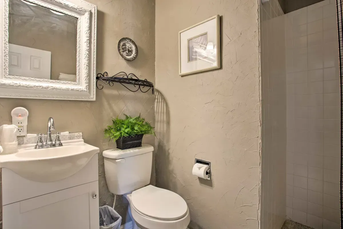 a bathroom with a toilet , sink and mirror .