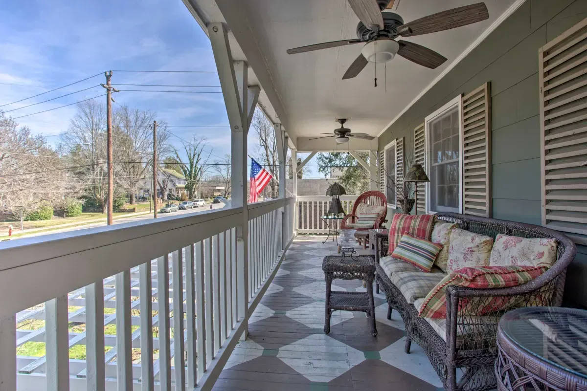 a porch with a couch and chairs and a ceiling fan .