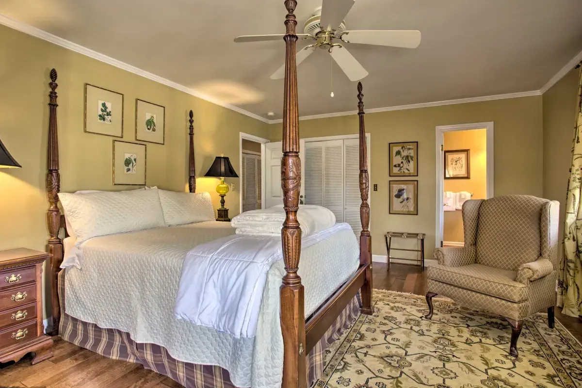 a bedroom with a four poster bed and a ceiling fan