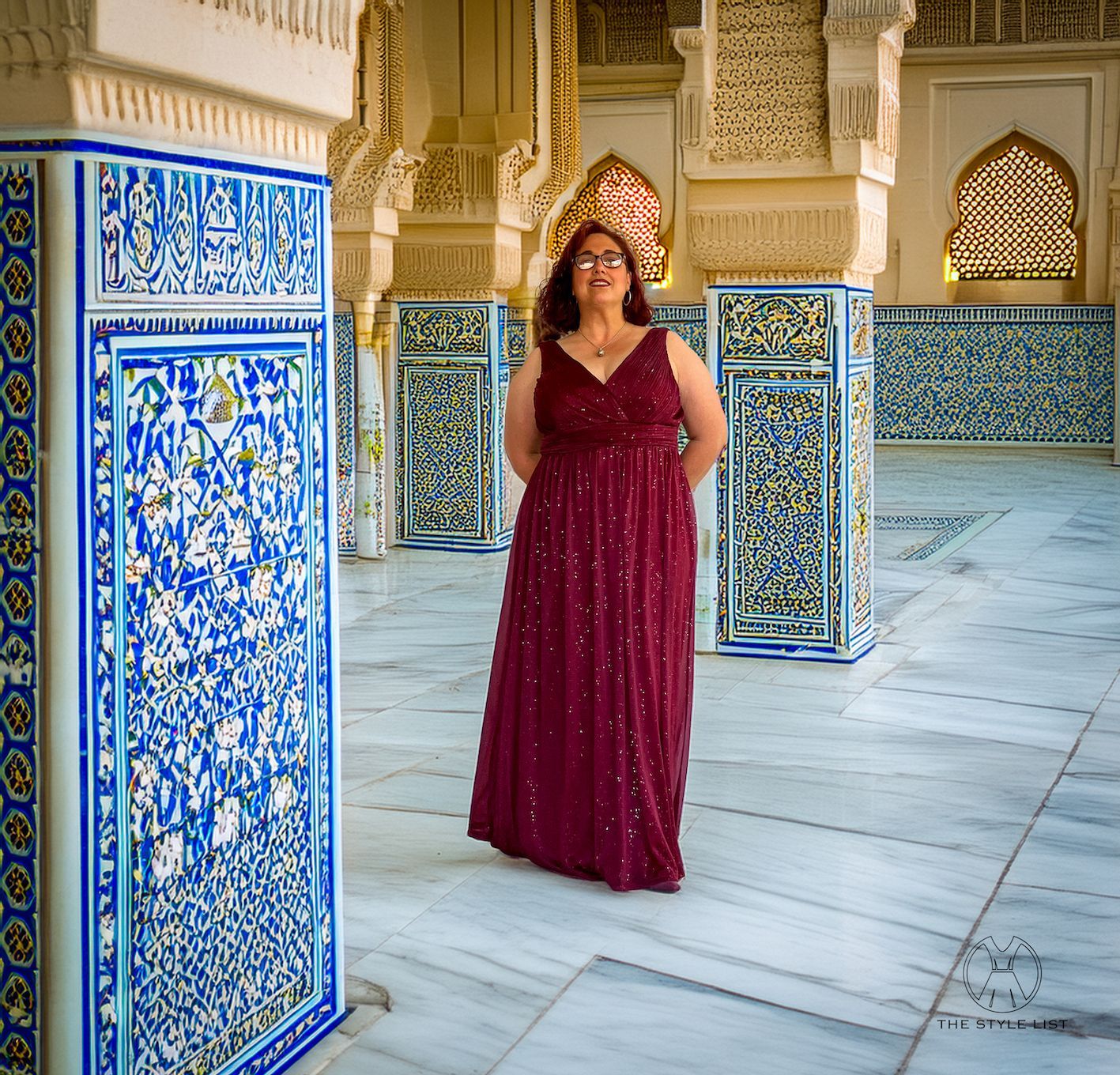 A woman in a long red dress is standing in a hallway