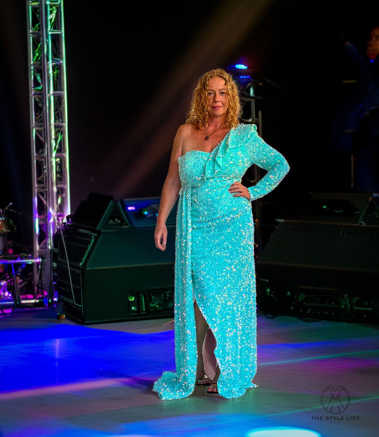 A woman in a blue dress is standing on a stage