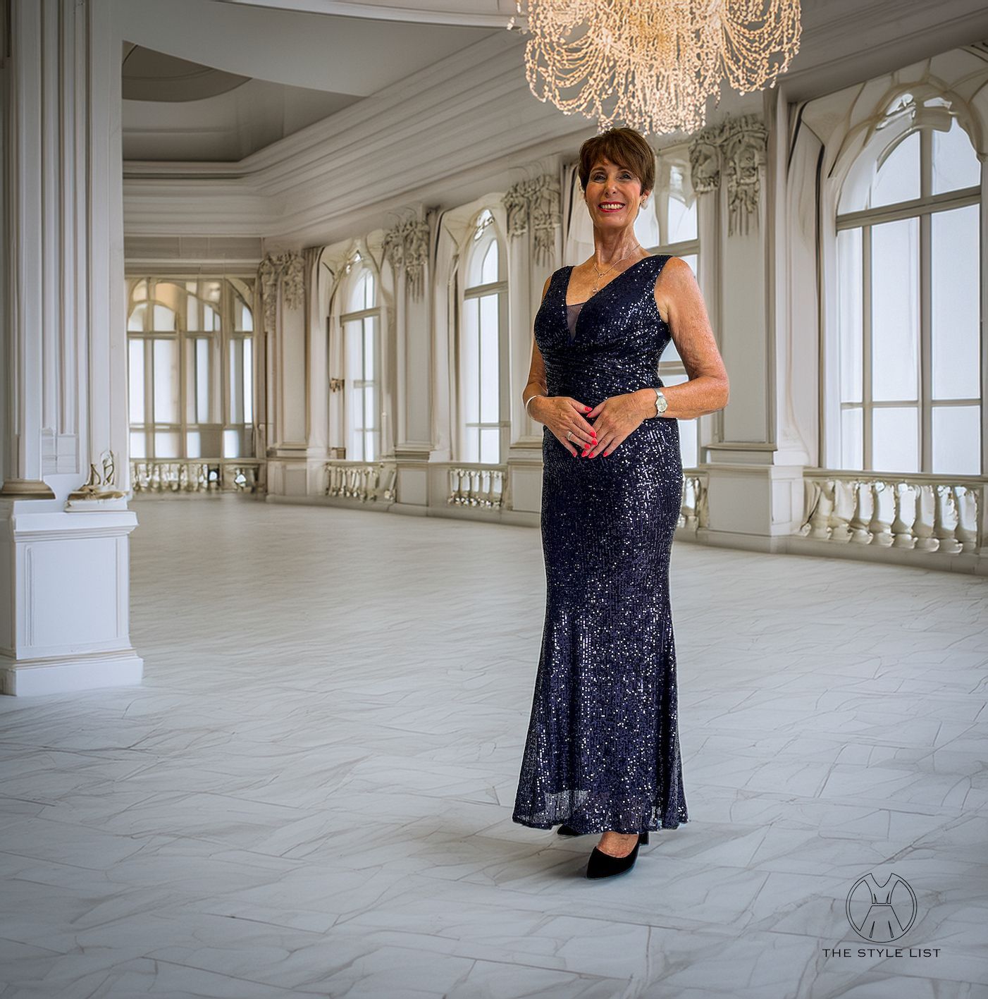 A woman in a blue sequined dress is standing in an empty room