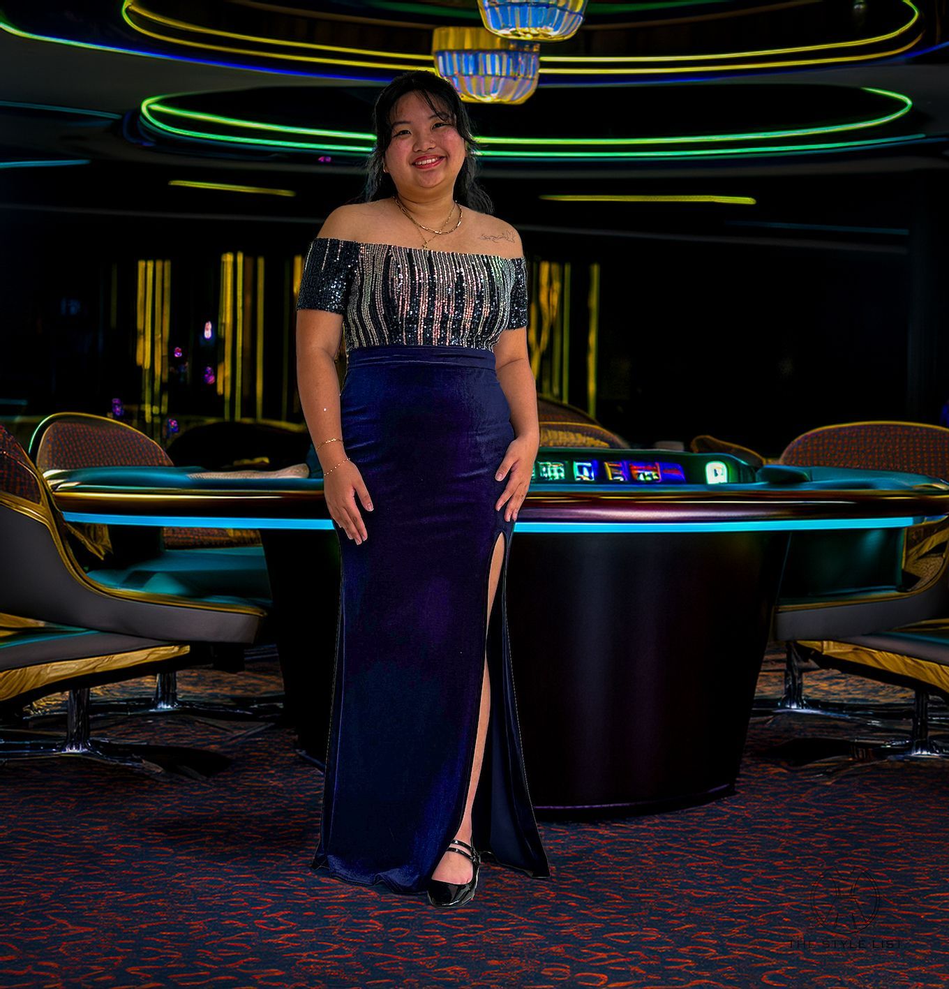 A woman in a blue dress is standing in front of a table
