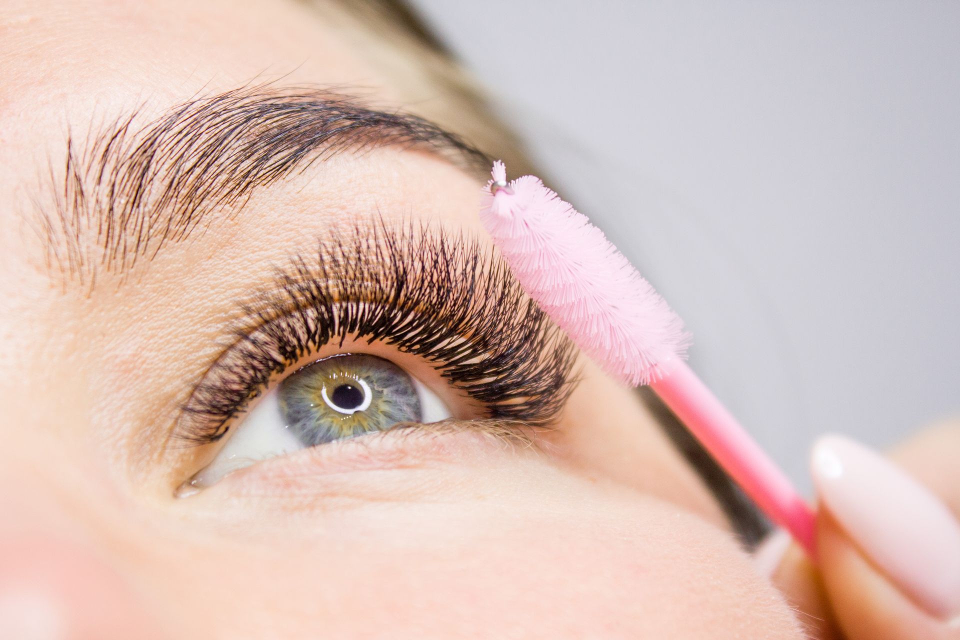 a close up of a woman 's eye with a pink brush