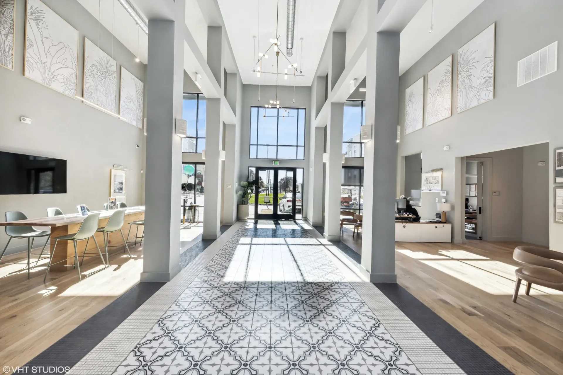 Bright, modern apartment community lobby with high ceilings, pillars, and seating.