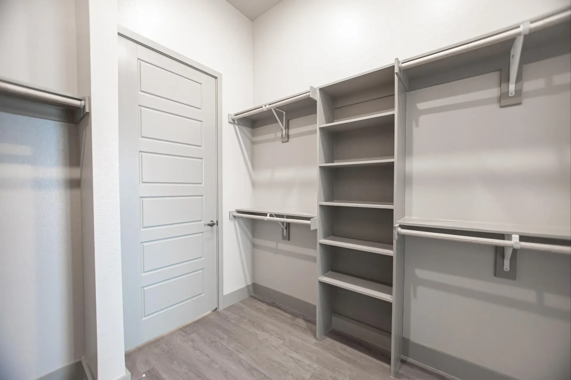 Walk-in closet with built-in shelves and hanging rods in a modern apartment.