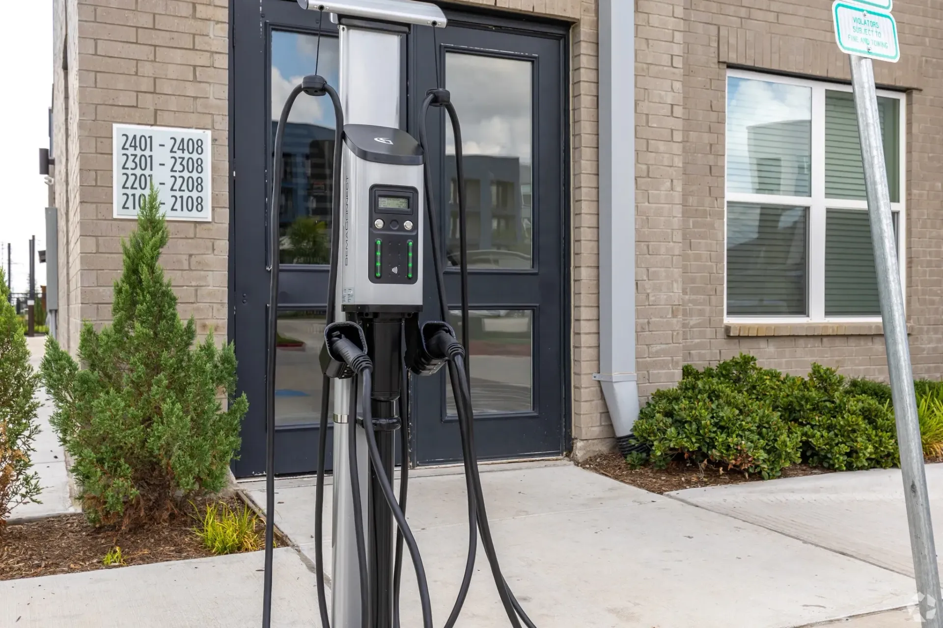 Electric vehicle charging station outside the apartment building entrance.