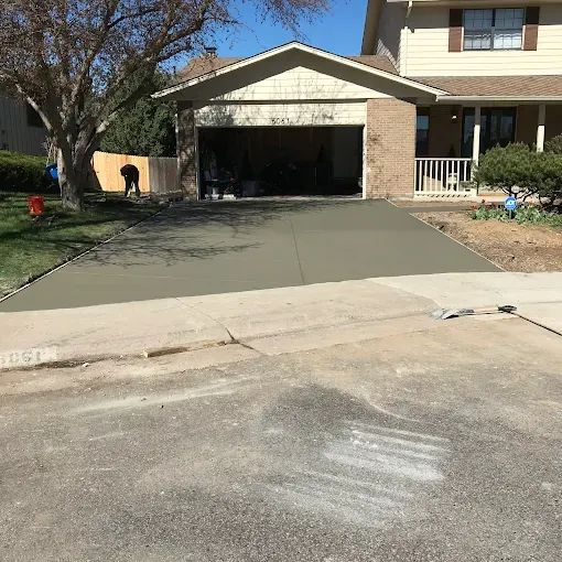 A large brick house with three garage doors and a large driveway.