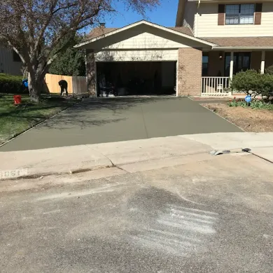 A concrete driveway is being built in front of a house.