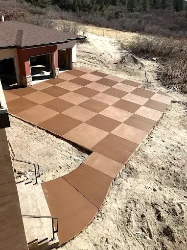A checkered concrete walkway leading to a house.