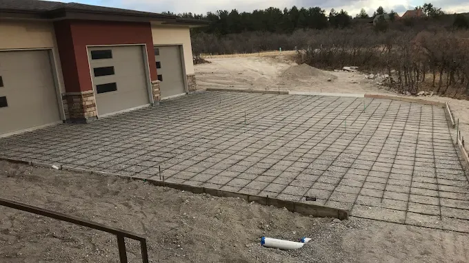 A concrete foundation is being built in front of a house.