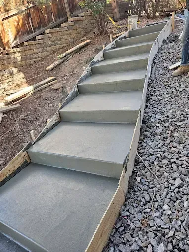 A person is standing next to a set of concrete stairs being built.