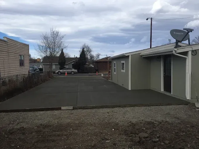 A concrete foundation is being built in front of a house.