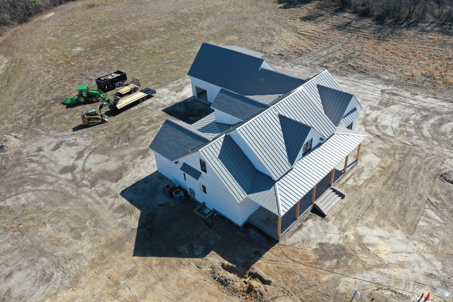 An aerial view of a house under construction in a dirt field.