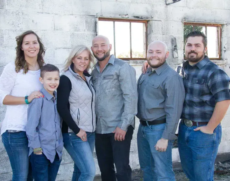 Under the Stars Farm family posing for a picture in front of a brick wall.