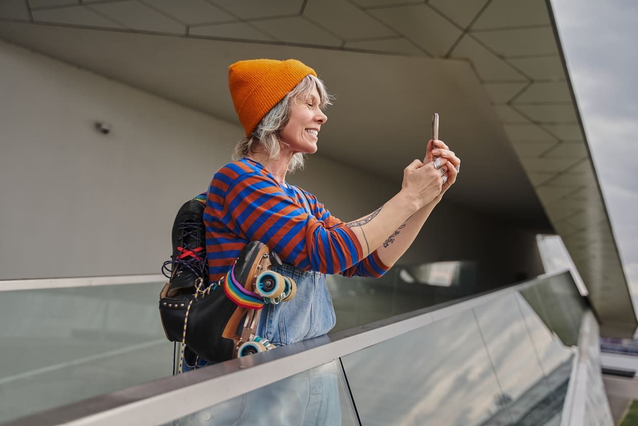 a woman is taking a picture of herself with her cell phone .