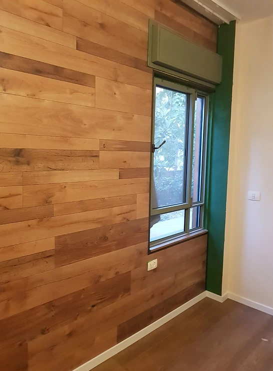 A room with a wooden wall and a window.