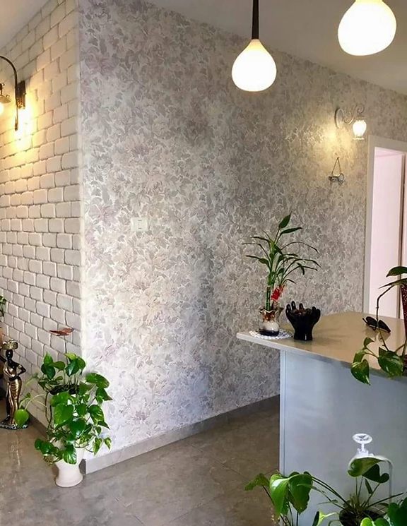 A room with a brick wall and a counter with plants on it.
