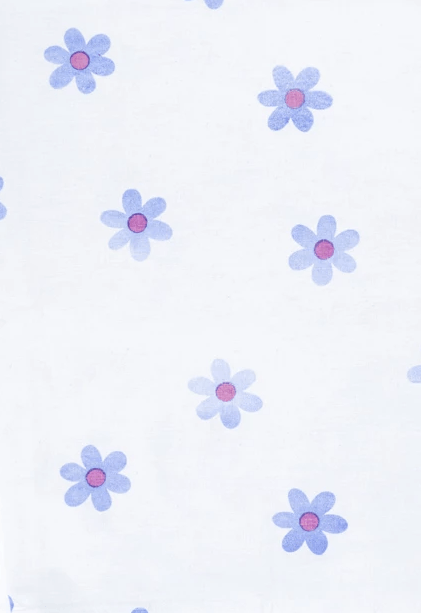 A close up of a white cloth with purple flowers on it.
