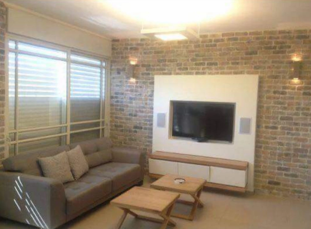 A living room with a couch , table , and television.