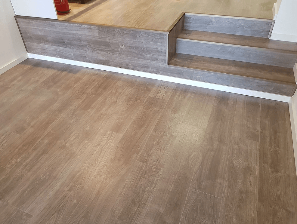 A wooden floor with stairs in a room.